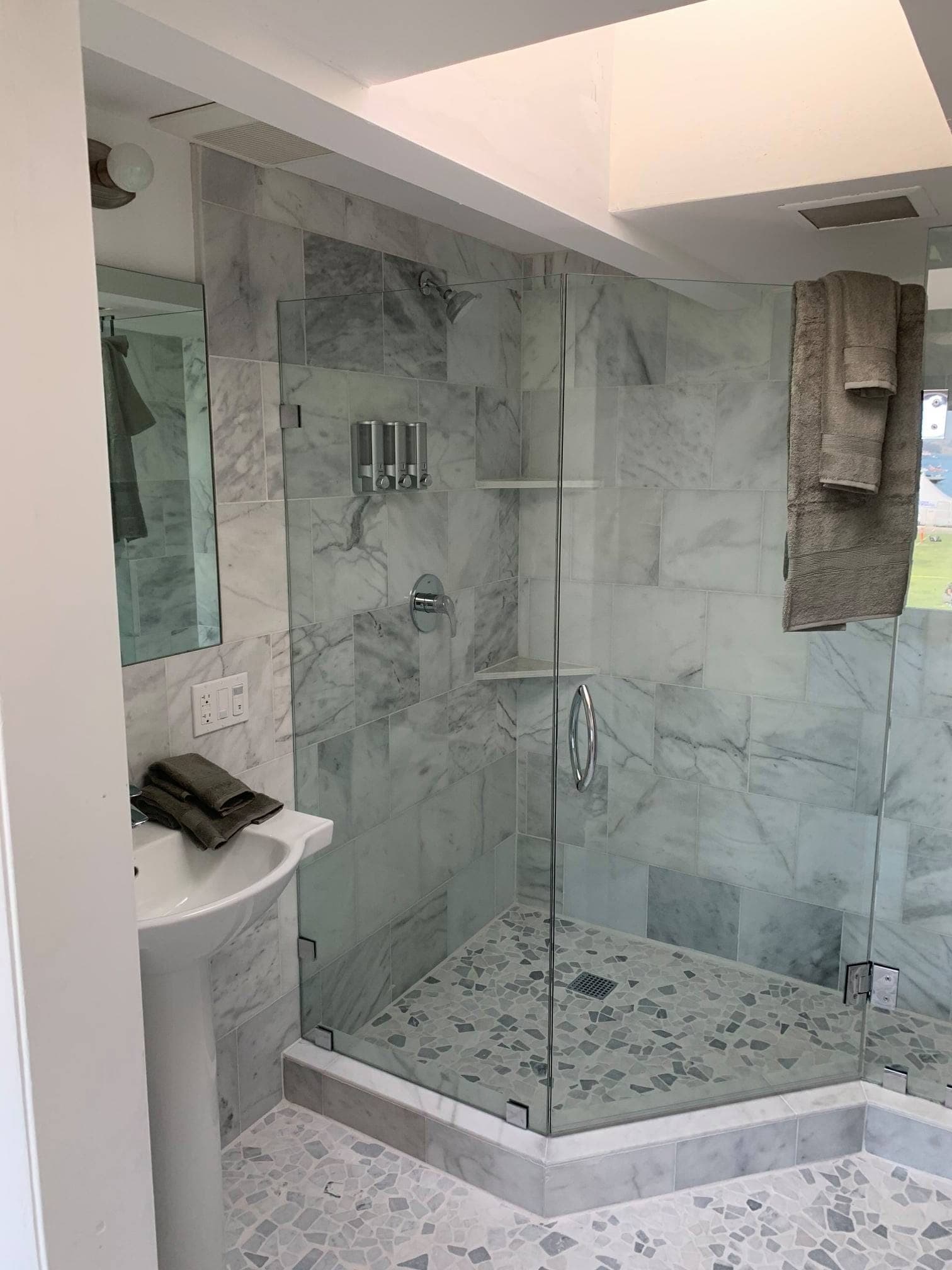 Marble-tiled ensuite bathroom with a walk-in glass shower